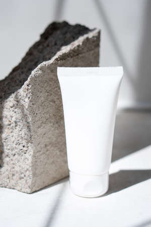 Clean white cream tube with trendy shadows and stone textureの写真素材