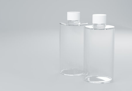 Two clear plastic shampoo bottles standing on gray background 3D render business templateの写真素材