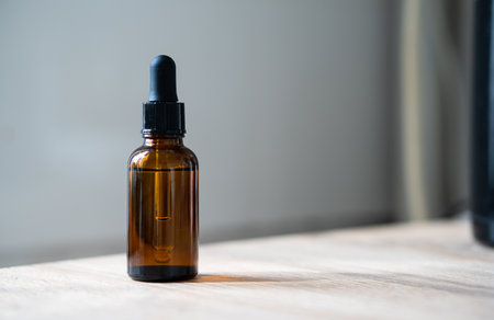 Amber glass serum oil dropper bottle on wooden table mock-up, cosmetic container daylight shotの写真素材