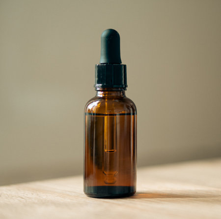 Amber glass serum oil dropper bottle on wooden table mock-up, cosmetic container daylight shotの写真素材