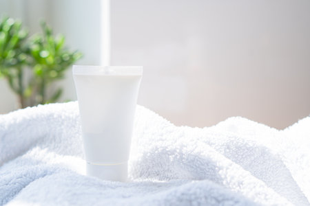 White cream tube and towel in real room interior mock-up, beauty and care product packaging templateの写真素材