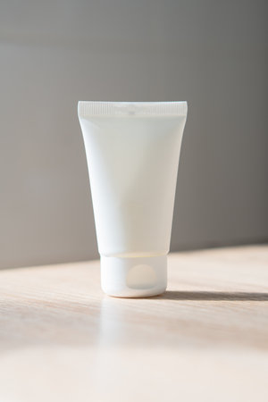 White cream tube on wooden table mock-up, beauty and care product packaging templateの写真素材