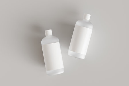 Two plastic cosmetic containers with labels, shampoo bottles laying on gray background front view 3D render mockupの写真素材