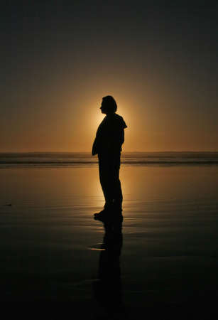 silhouette of the man at the Pacific ocean beach at sunsetの写真素材