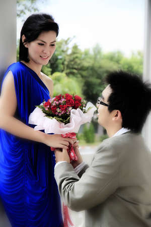Man giving bunch of flowers to girlfriendの写真素材