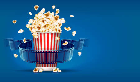 Popcorn for cinema and movie film tape on blue background.の写真素材