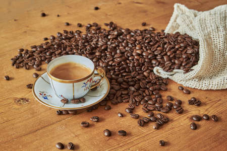 Vintage espresso cup on a wooden table. Antique espresso cup and coffee beans on a wooden vintage table. Art deco espresso cup in Rome, Italy.の写真素材