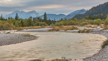 Panoramic view of the Isar in the Bavarian alps. River flows through a panoramic mountain landscape....