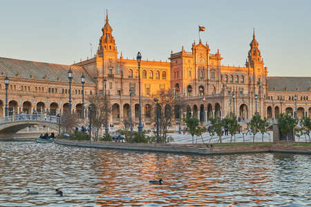 Sunset at the plaza de espana in Seville, Andalusia, Spain. Monumental building during sunset with reflecting river in the foreground.の写真素材