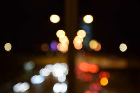 Blurred traffic lights at night. Blurry city lights at night. Bokeh lights at night in Munich.の写真素材