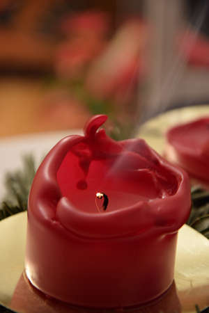 Blown out red christmas candle with smoke. Smoking red candle.の写真素材