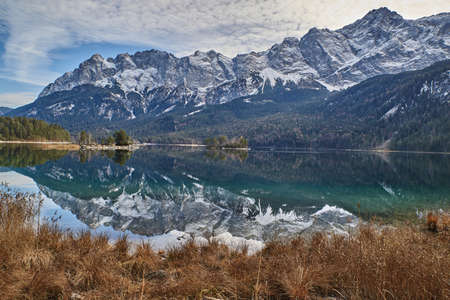 Reflecting mountain lake in the german alps. Turquoise mountain lake in bavaria. Eibsee in Bavaria.の写真素材