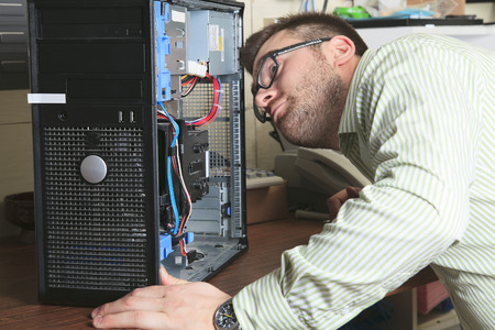 A happy worker technician at work with computer.