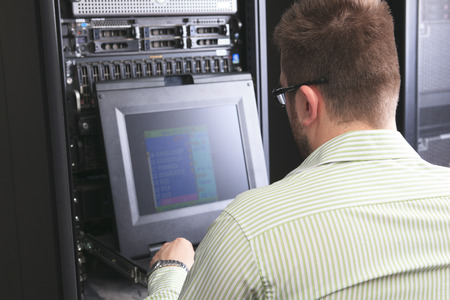 A happy worker technician at work with computer.
