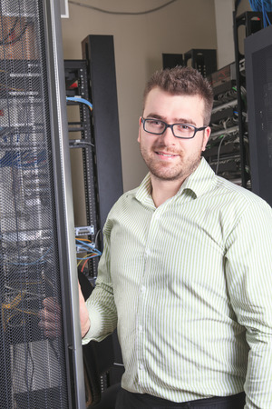 A happy worker technician at work with computer.