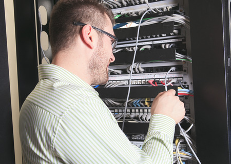 A happy worker technician at work with computer.