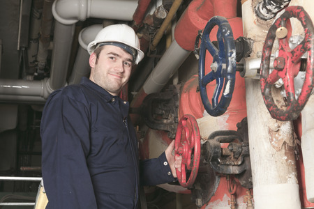 maintenance engineer checking technical data of heating system equipment in a boiler room