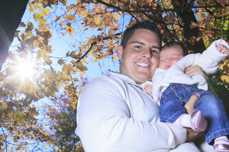 A Family enjoying golden leaves in autumn park