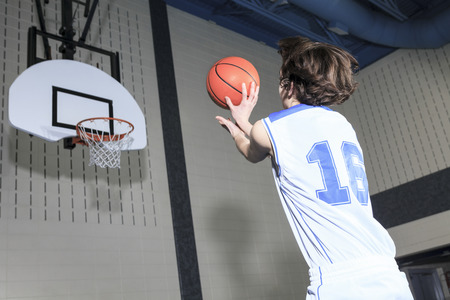 A teenager basketball player play his favorite sport