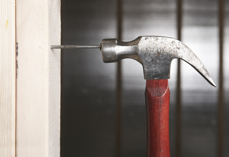 Close up of man hitting nail by hammerの写真素材