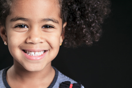 Portrait of a cute african american little boy, isolated on black backgroundの写真素材