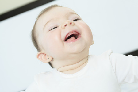 Portrait of a crawling baby on the bed in her roomの写真素材