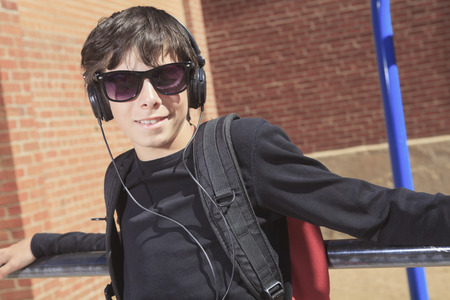 A teen boy listening to music with sun glassesの写真素材