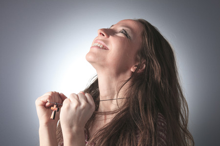 A nice woman praying on grey backgroundの写真素材