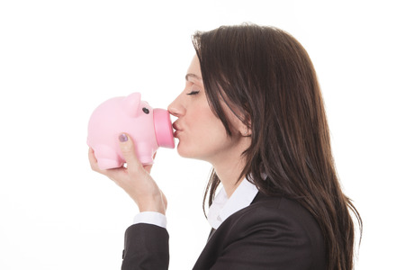 Glasses sale concept. Happy woman kissing piggy bank wearing eyewear glasses. Mixed race Asian Chinese / Caucasian female model isolated on white background.の写真素材