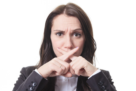 A business woman with a sign of x in front of her mouth for confidentialityの写真素材