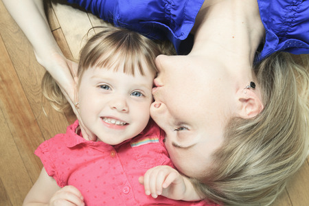 A mother lay in the living room floor with daughterの写真素材