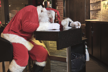 A Santa claus sleep at the bar. Too drunk.の写真素材