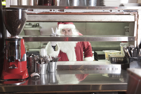 A Santa claus smiling in undustrial kitchenの写真素材
