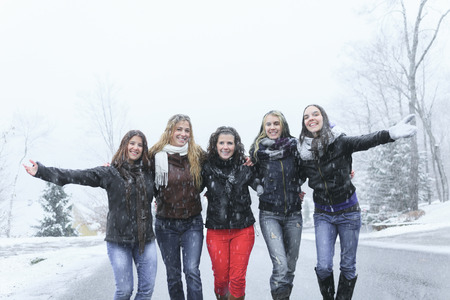 A Group of excited young girl friends outdoors in winterの写真素材