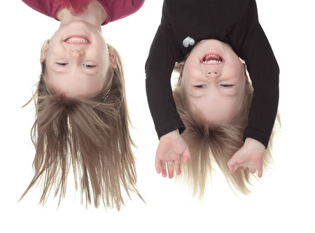 A head portrait os two little girls in an upside-down position.  On a white background.の写真素材