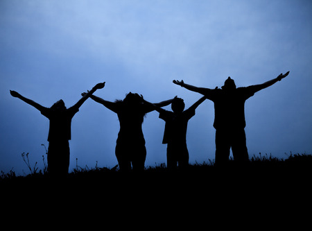 The family from three persons welcomes the sunset sun.の写真素材