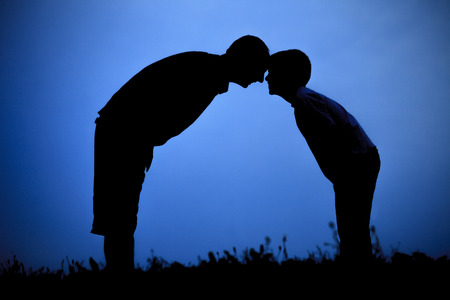 Father with sons playing on sunset meadowの写真素材