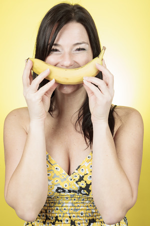An happy woman in front of a yellow background.の写真素材