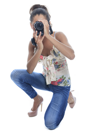 Girl-photographer takes snaps, isolated on whiteの写真素材