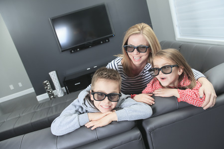 family sitting on a sofa in her living roomの写真素材