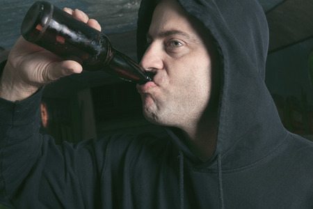 Man looks depressed with bottle in his hand.の写真素材