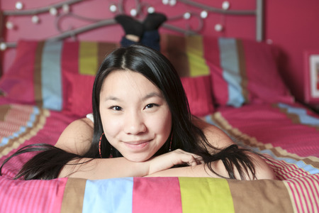 A Asian American teen lay on his bedroomの写真素材