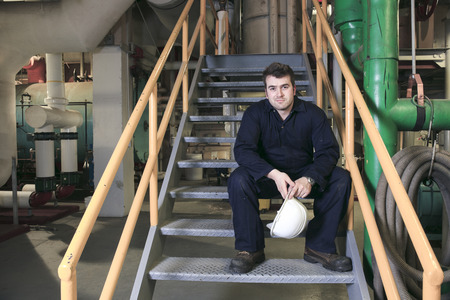 Maintenance engineer checking technical data of heating system equipment in a boiler roomの写真素材