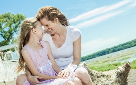 A Young mother and her young daughter fun time together outdoors.の写真素材