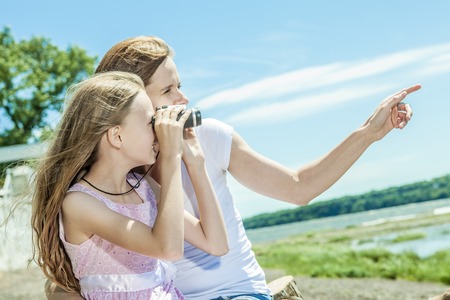 A Young mother and her young daughter fun time together outdoors.の写真素材
