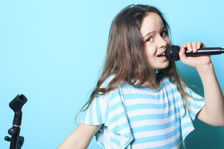 A girl sing in a microphone having good time.の写真素材