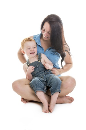A redhead baby boy with his mother over a isolated white background