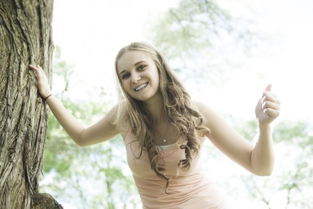 A Beautiful smiling girl standing over green summer background