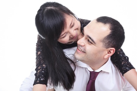 Portrait of smiling couple embracing on white backgroundの写真素材