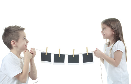 two cute child holding a blank photo frame ropeの写真素材